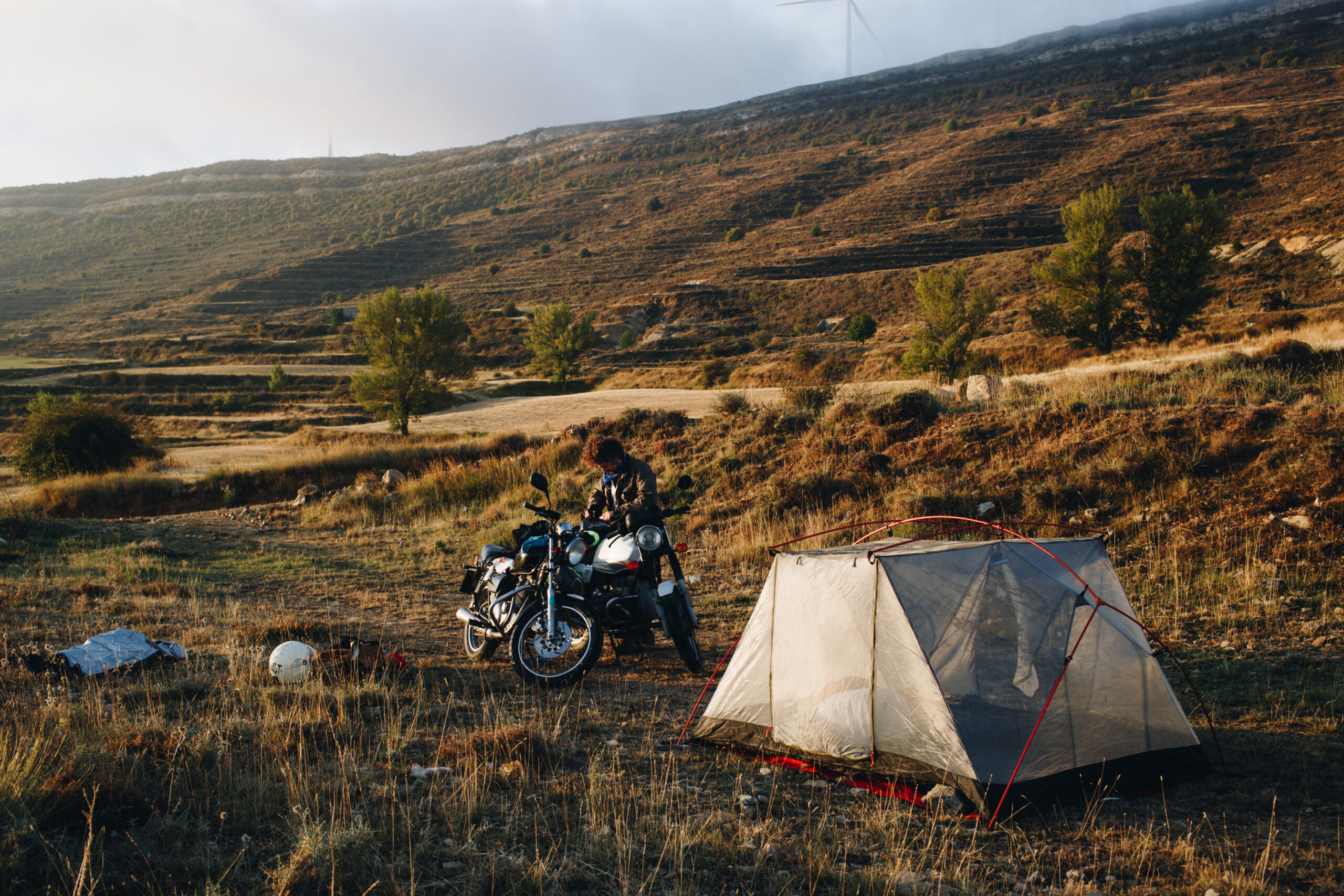 Adventure motorcyclist camping in wild